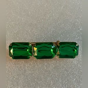 Beautiful vintage gold tone green foil back rhinestone bar brooch.